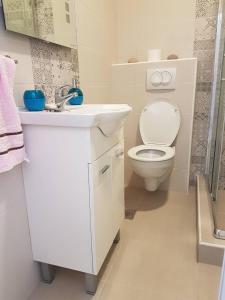 uma casa de banho branca com um WC e um lavatório em Studio em Tivat