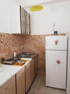 uma cozinha com um frigorífico branco e um lavatório em Studio em Tivat
