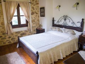 a bedroom with a large bed and a window at To Archontiko Guesthouse Villa in Stavroupoli