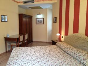 a bedroom with a bed and a desk and a table at La Dependance in Menaggio