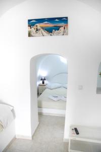 a room with a bed and a picture of a beach at White Side Suites in Oia