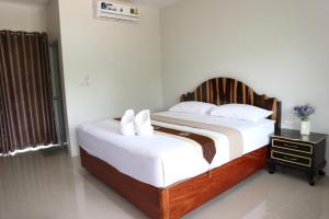 a bedroom with a large bed with white sheets at ศุภสิรีวิลล์ in Ubon Ratchathani