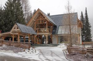 ein großes Holzhaus im Schnee in der Unterkunft Apartment Bad Kleinkirchheim in Bad Kleinkirchheim