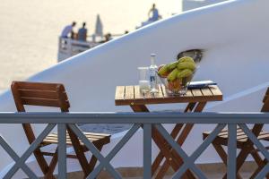 a table with a bowl of bananas on a balcony at White Side Suites in Oia