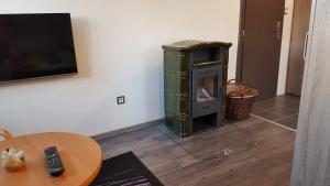 a living room with a green stove next to a table at Room with a High Tatras view and Fireplace in Štrba