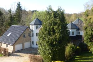 uma grande casa branca com garagem em Ferienwohnung am Grölisbach em Roetgen