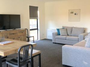 a living room with a couch and a table at Townhouse Feel in Irishman in Twizel