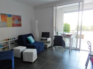 uma sala de estar com uma cadeira azul e uma mesa em Appartement les Pieds dans l'eau ! em Le Lavandou