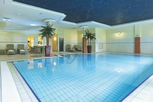 a large swimming pool in a hotel room at Fletcher Familiehotel Paterswolde in Eelde-Paterswolde