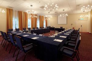 una grande sala conferenze con un lungo tavolo e sedie di Fletcher Familiehotel Paterswolde a Eelde-Paterswolde Altre 22 foto