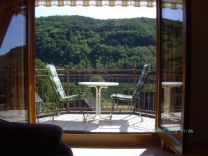 a balcony with a table and chairs and a view of the mountains at Moselblick in Sankt Aldegund