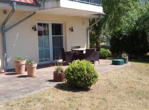 eine Terrasse mit Tisch und Stühlen in einem Hof in der Unterkunft Waldperle in Ostseebad Karlshagen