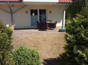 eine Terrasse mit Tisch und Stühlen vor einem Haus in der Unterkunft Waldperle in Ostseebad Karlshagen + 6 Fotos