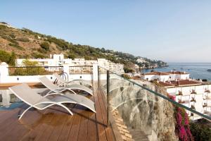 a group of white chairs on a balcony overlooking the ocean at Chezmoihomes Duplex Penthouse with Swimming Pool in La Herradura
