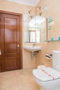 a bathroom with a toilet and a sink and a mirror at Hotel Las Anclas in El Astillero