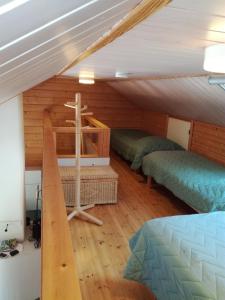 um quarto com 3 camas num sótão em Aaria Apartment em Tahkovuori