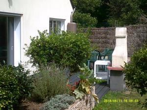 a garden with a bench and some bushes and a fence at Soizic' house in Trébeurden