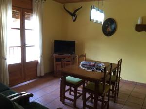 a dining room with a table and chairs and a television at La Perxada de Besolí in Areu