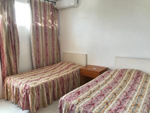 une chambre d'hôtel avec deux lits et une fenêtre dans l'établissement Bella Vista Mauritius, à Grand Baie 37 autres photos