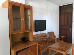 un salon avec une télévision, une table et des chaises dans l'établissement Bella Vista Mauritius, à Grand Baie