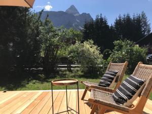 two chairs with pillows sitting on a wooden deck at Schneehaus Lodge in Ehrwald