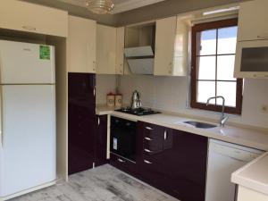 a kitchen with a white refrigerator and a sink at Yıldız Pansiyon in Sapanca