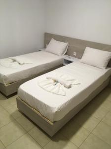 two beds with white sheets and towels on them at Villa Martini in Kissamos