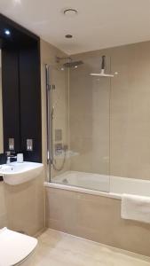 y baño con ducha, lavabo y bañera. en Great Northern Road Apartment, en Cambridge