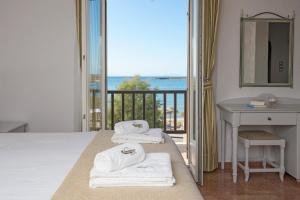 ナウサにあるContaratos Beach Hotelの海の景色を望むベッド付きのホテルルームです。