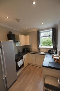 a kitchen with a refrigerator and a counter top at Sighthill 3 Bedrooms with Private Garden in Edinburgh