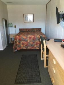 a hotel room with a bed and a desk at Winkys Motel in Estevan