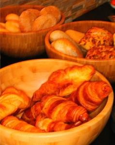 a wooden bowl filled with different types of bread at De Herbergh van Flielant in Oost-Vlieland