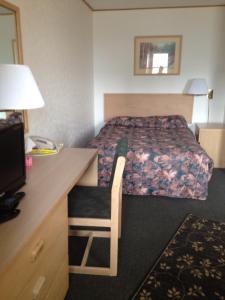 a hotel room with a bed and a desk at Winkys Motel in Estevan