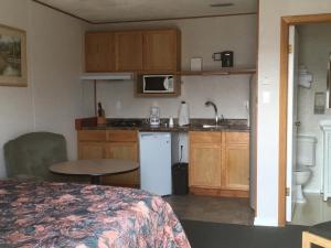 a small kitchen with a bed and a table in a room at Winkys Motel in Estevan