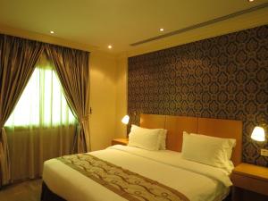 Un dormitorio con una cama grande y una ventana en Etab Hotels & Suites, en Al Khobar