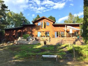 a log home with a house at Wonderful wooden house next to lake and Stockholm archipelago in Boo