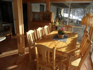 a wooden table and chairs in a room at Semestervilla vid sjö in Arkelstorp