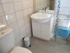 y baño con lavabo y aseo. en Bungalow de Kermoal en Trébrivan