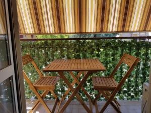 einen Holztisch und zwei Stühle auf dem Balkon in der Unterkunft La Dolce Vita Rome Ciampino in Ciampino