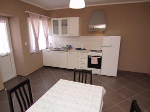 a kitchen with a table and a white refrigerator at Federica A2+1 in Veli Lošinj
