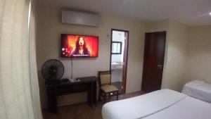 Ruan Beach في غاجيرو: غرفة نوم مع سرير وتلفزيون على الحائط
