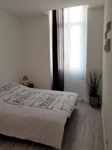 Una cama blanca en un dormitorio con ventana. en Coeur Vieux Port tout équipé, en Marsella