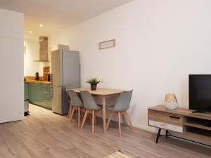 Una cocina con mesa y sillas y un refrigerador. en Coeur Vieux Port tout équipé, en Marsella