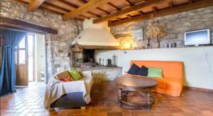 a living room with an orange couch and a table at Casa Mazzocchi Vista su Poppi in Poppi