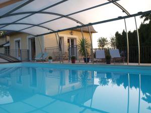 a swimming pool with a white canopy over it at Chambres d'Hôtes Entre Deux Rives in Honfleur +15 photos