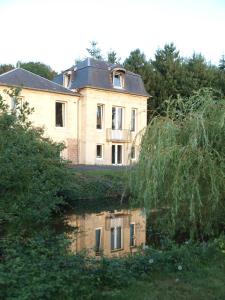 ein altes Haus mit einer Reflexion in einem Wasserkörper in der Unterkunft Chambres d'Hôtes Entre Deux Rives in Honfleur
