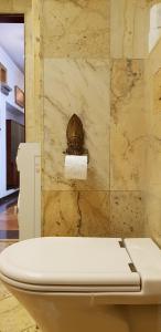 - białą toaletę w pokoju z kamienną ścianą w obiekcie Comfy & Cosy Apartment w mieście Katowice