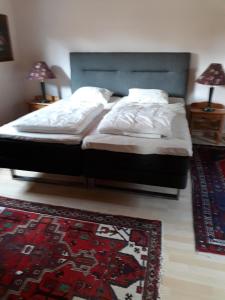 1 dormitorio con 2 camas y alfombra en el suelo en Semestervilla vid sjö en Arkelstorp