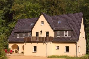 a large white house with a black roof at Ferienheim Kuckuckswinkel - Familiensuite Marlene in Schöna