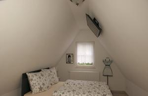 a small bedroom with a bed and a window at Ferienheim Kuckuckswinkel - Familiensuite Marlene in Schöna